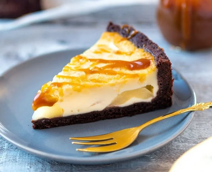 Birnen-Schmand-Kuchen mit Karamellsoße auf einem Teller serviert.