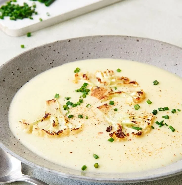 Cremige Blumenkohlcremesuppe im weißen Teller serviert