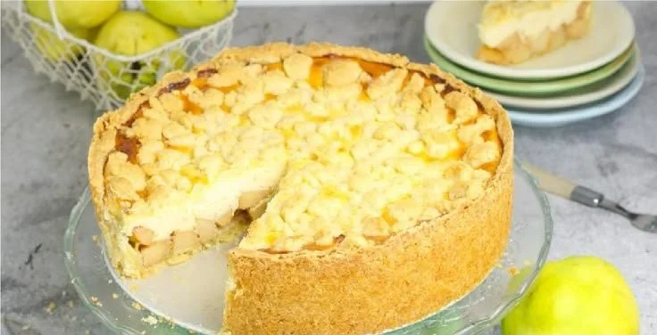 Käsekuchen mit Quitten und Streuseln auf einem Teller.