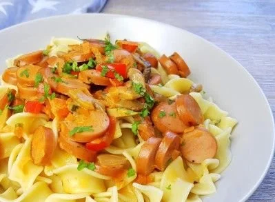 Pasta mit Gemüse auf einem Teller garniert mit frischen Kräutern