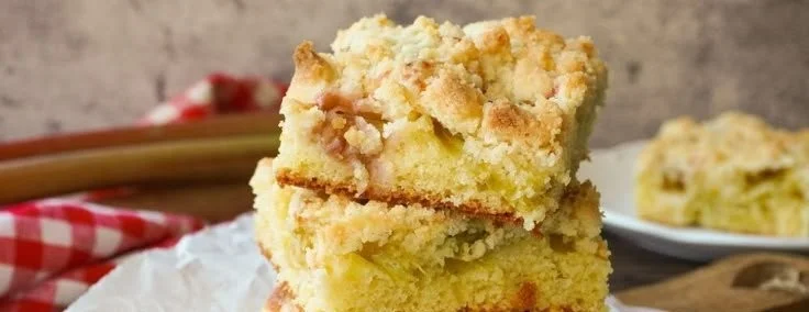 Rhabarberkuchen mit Streuseln auf einem Teller, frisch gebacken und dekoriert.
