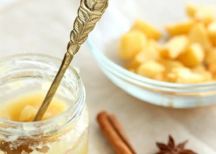 Winterapfel-Marmelade mit Marzipan in einem Gläschen auf einem Holzbrett.